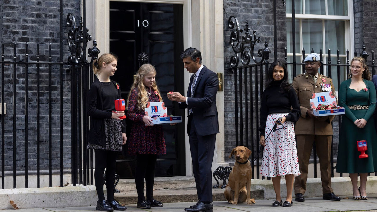 31/10/2022. London, United Kingdom. Prime Minister Rishi Sunak, his wife Akshata Murthy and Nova, their pet Labrador buy a poppy from Royal British Legion at the front door of 10 Downing Street. Picture by Simon Dawson / No 10 Downing Street